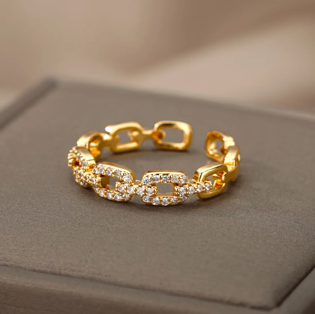Eleganter Ring in Goldfarbe mit funkelnder Liebeskette und Strasssteinen