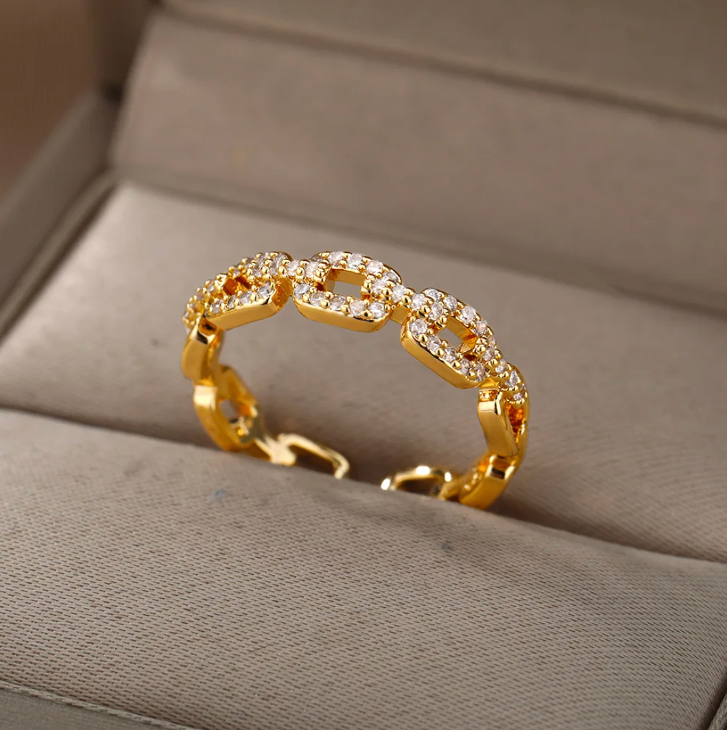 Eleganter Ring in Goldfarbe mit funkelnder Liebeskette und Strasssteinen